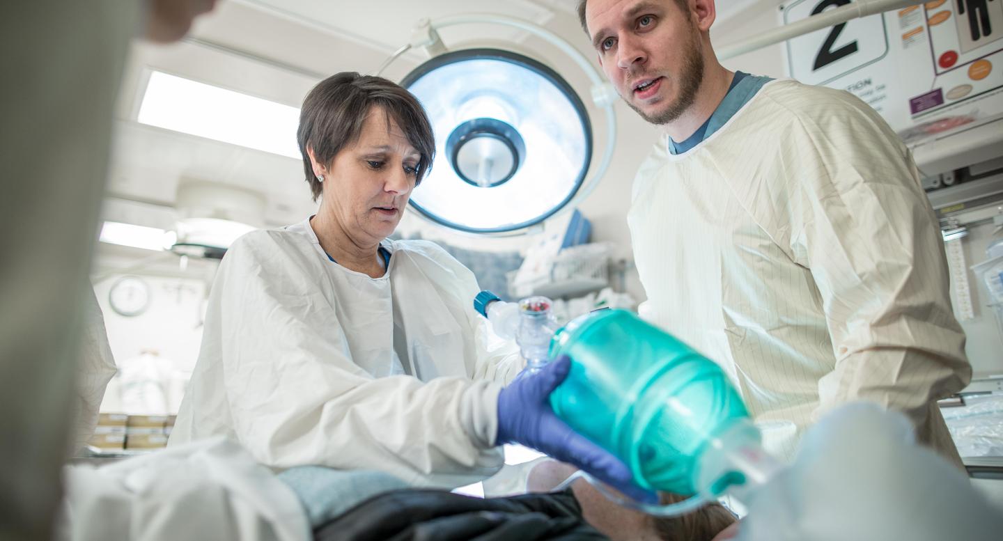 A team of emergency room providers works on a patient