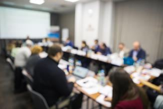 A board of directors sits around a conference table