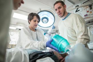 A team of emergency room providers works on a patient